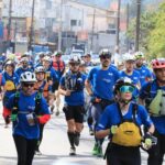 Atletas correndo de uniforme azul na competição Haka Race 2021
