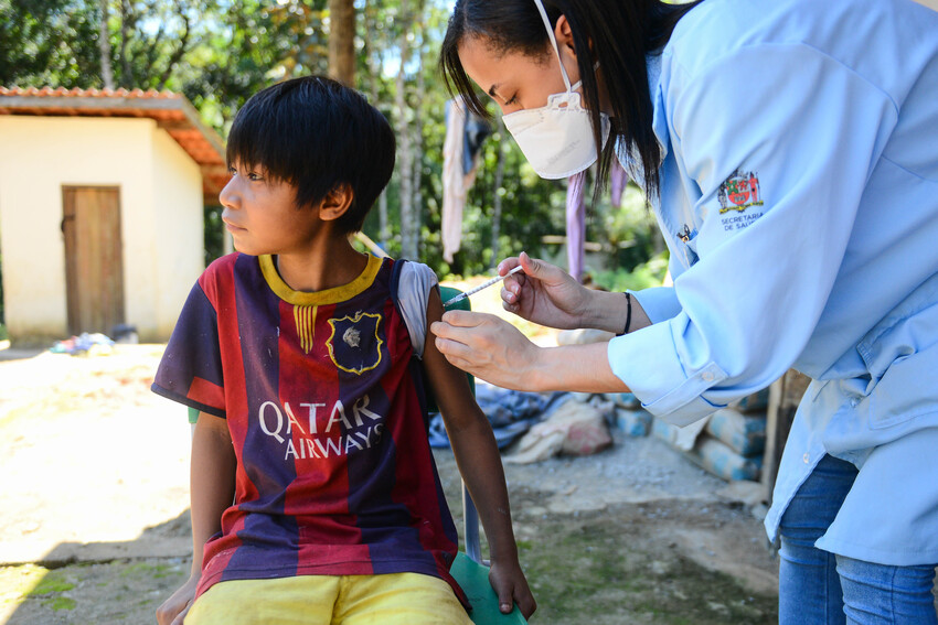 criança indígena sendo vacinada