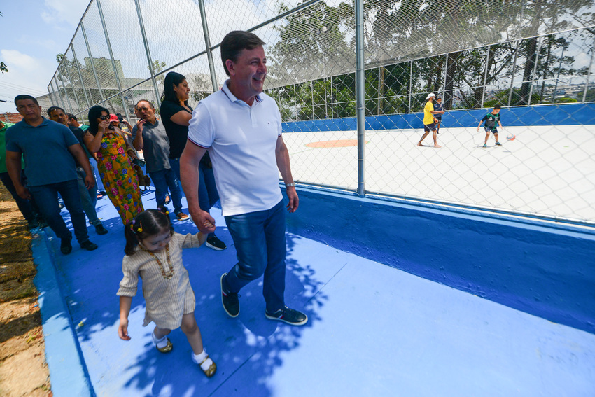 Orlando Morando caminha com criança em praça-parque