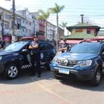 GCMs de Ribeirão Pires ao lado de viatura
