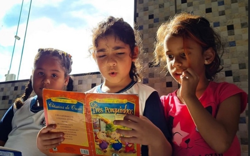 Crianças lendo livro 