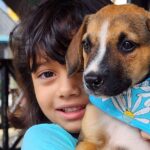 Criança com filhote de cachorro