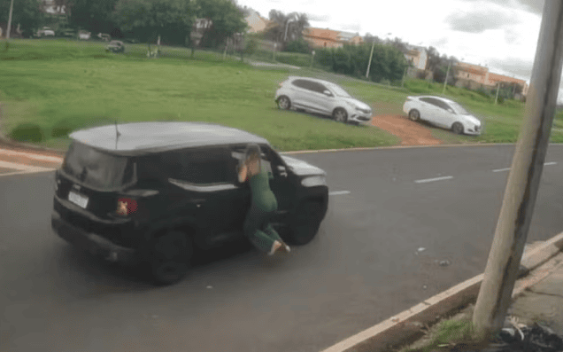 mulher pendurada na janela do carro