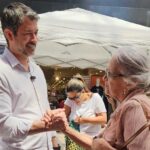 Eduardo Leite falando com mulher na rua