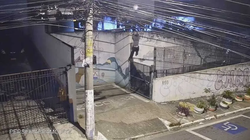 homem pulando muro de escola